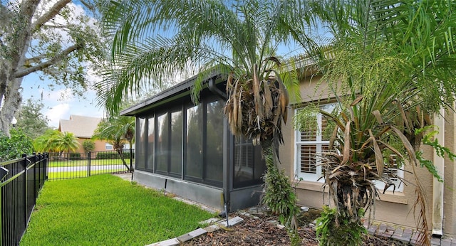 view of side of property featuring a yard and a sunroom