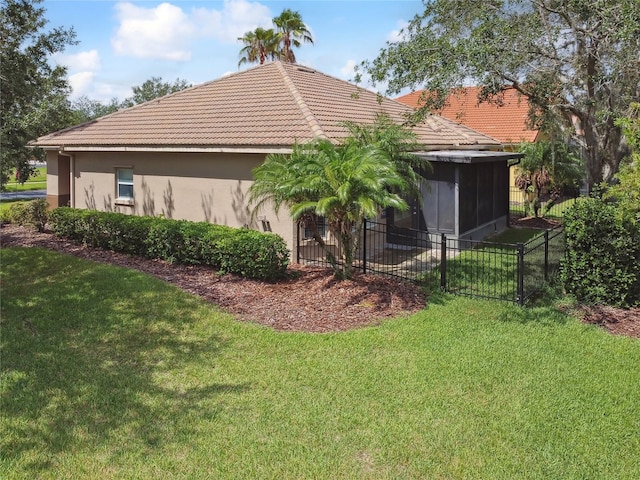 view of side of property with a yard and a sunroom