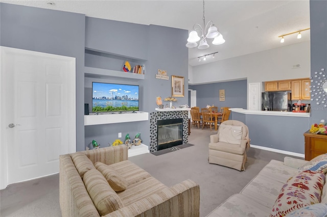 living room with rail lighting, light colored carpet, a notable chandelier, and high vaulted ceiling