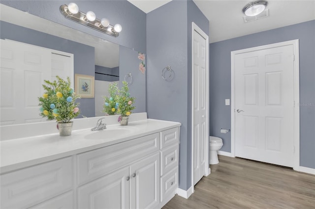 bathroom featuring vanity, toilet, and hardwood / wood-style floors