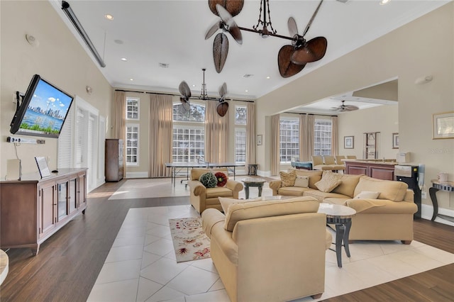 tiled living room with crown molding and a notable chandelier