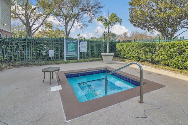 view of swimming pool featuring a hot tub