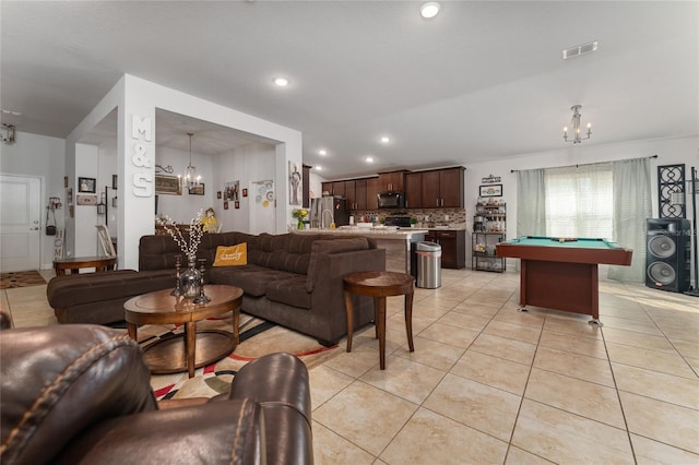 tiled living room featuring pool table and a notable chandelier