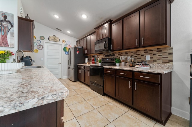 kitchen with vaulted ceiling, sink, black appliances, dark brown cabinetry, and decorative backsplash