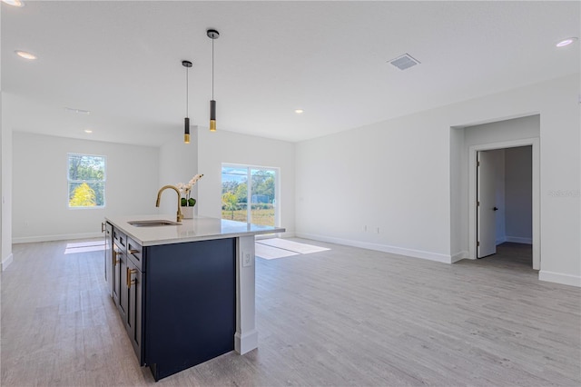 kitchen featuring pendant lighting, sink, a kitchen island with sink, and a wealth of natural light