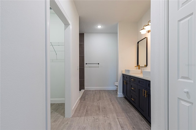 bathroom featuring vanity, wood-type flooring, and toilet