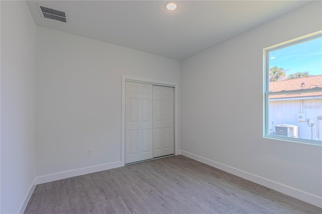 unfurnished bedroom with light hardwood / wood-style flooring and a closet