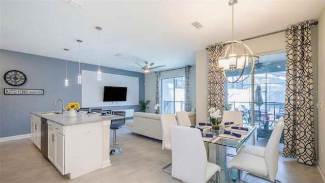 dining area with sink and ceiling fan with notable chandelier