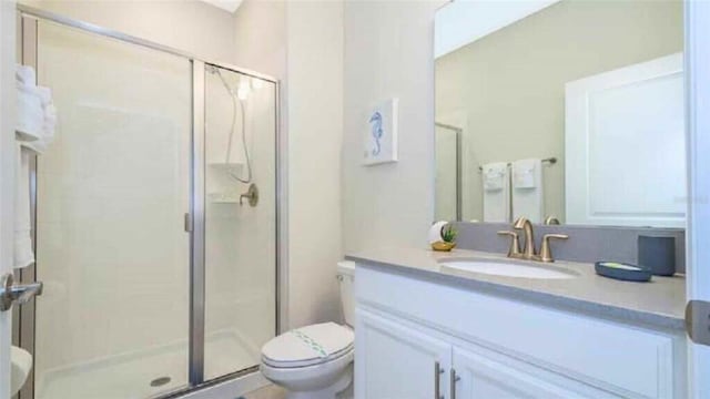 bathroom featuring vanity, toilet, and walk in shower