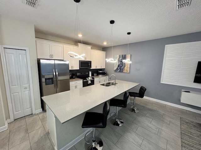 kitchen with pendant lighting, sink, a breakfast bar, appliances with stainless steel finishes, and white cabinets