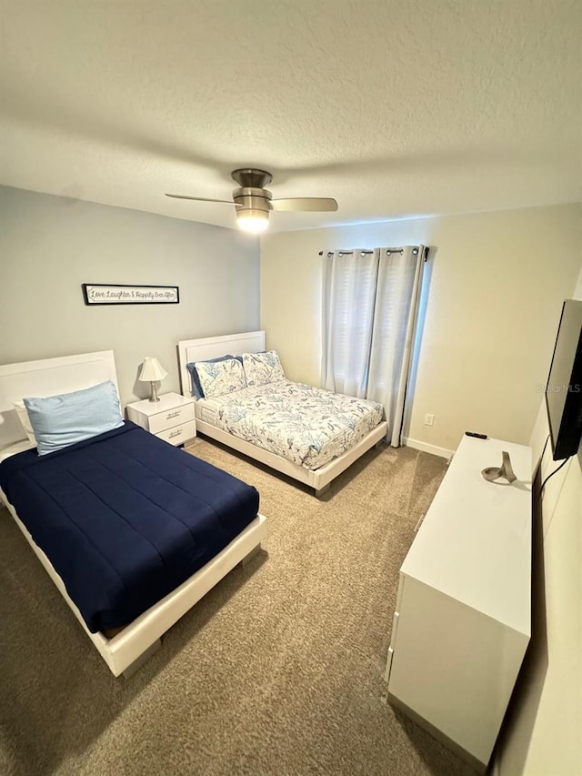 bedroom featuring ceiling fan, carpet floors, and a textured ceiling