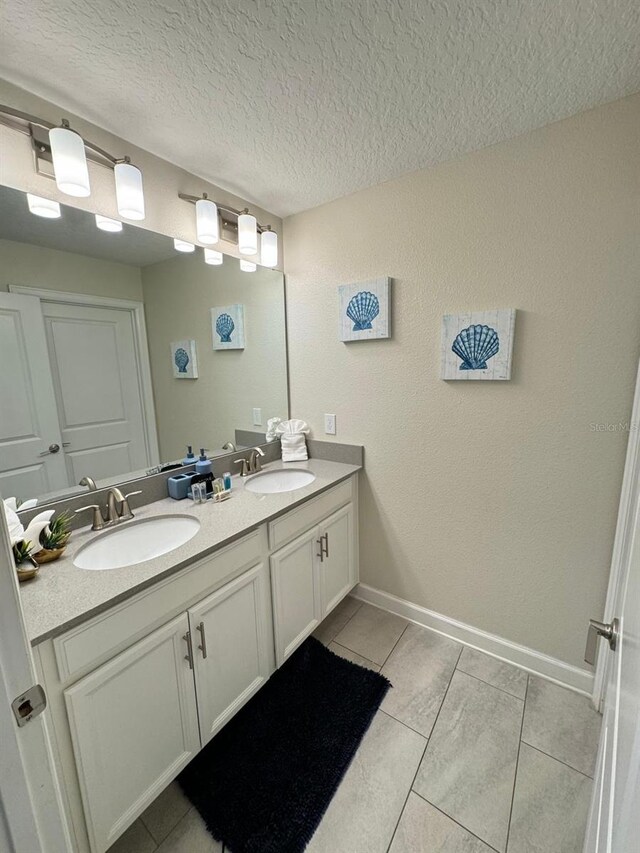 bathroom with vanity, tile patterned flooring, and a textured ceiling