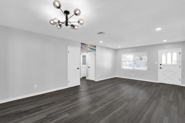 unfurnished living room with dark hardwood / wood-style flooring and a notable chandelier