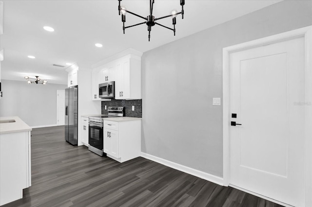 kitchen with backsplash, appliances with stainless steel finishes, dark hardwood / wood-style floors, and white cabinets