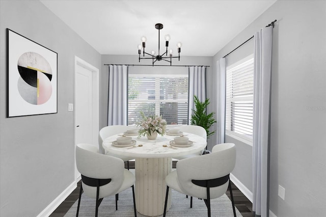 dining space featuring an inviting chandelier, plenty of natural light, and dark hardwood / wood-style flooring