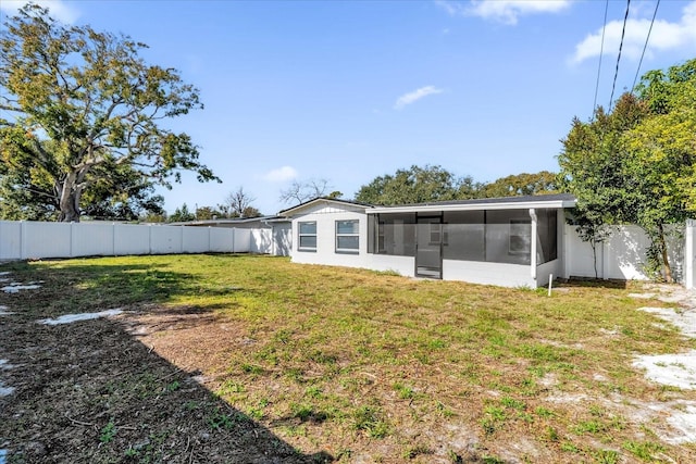 rear view of property with a sunroom and a yard