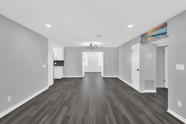 unfurnished living room with dark hardwood / wood-style floors and a chandelier