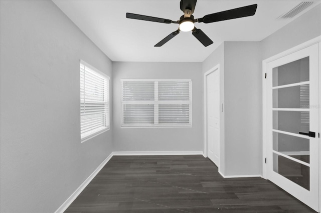 empty room with dark hardwood / wood-style floors and ceiling fan