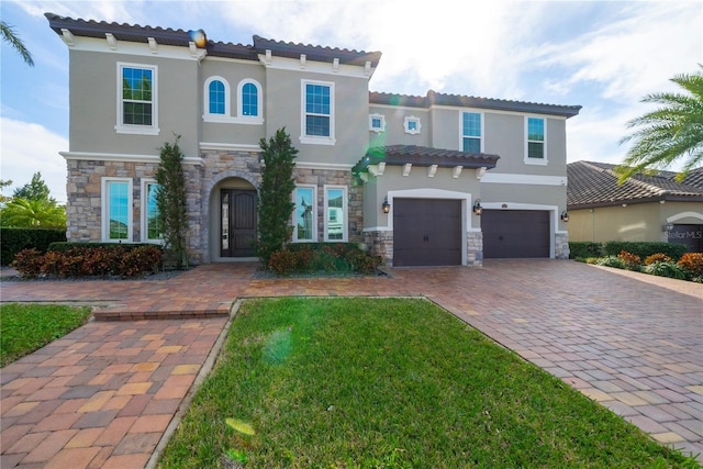 mediterranean / spanish-style home featuring a garage and a front lawn