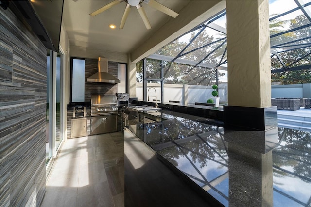 view of patio / terrace featuring a lanai, area for grilling, sink, and ceiling fan