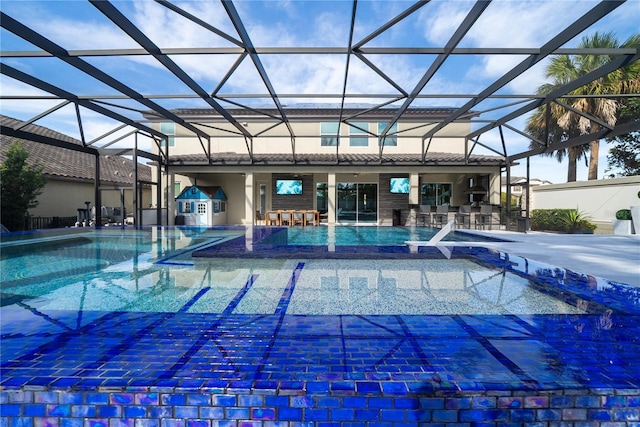 view of swimming pool featuring exterior bar, a jacuzzi, a patio, and a lanai