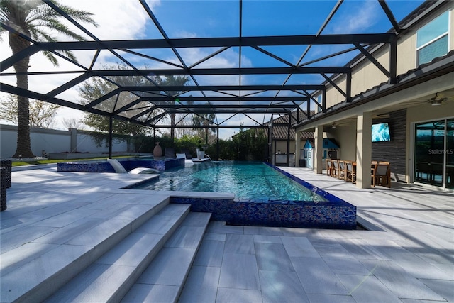 view of pool with a patio, exterior bar, ceiling fan, and a lanai