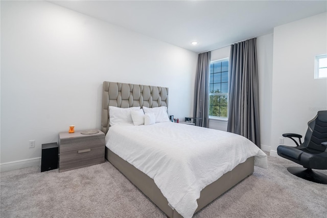 bedroom featuring multiple windows and light carpet