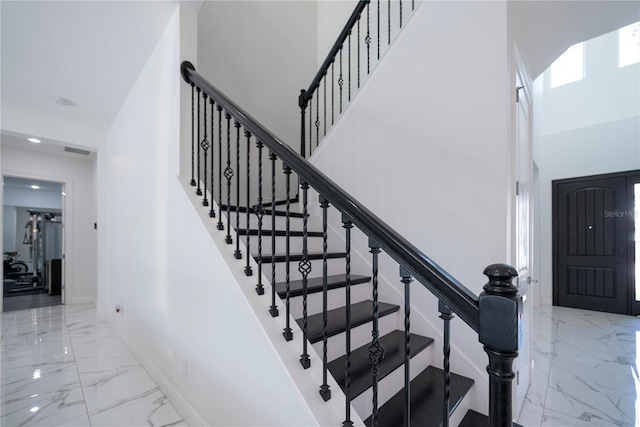 stairway featuring a high ceiling