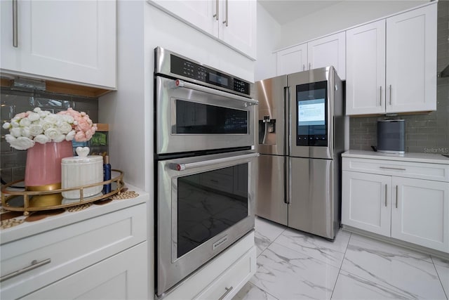 kitchen with white cabinetry, appliances with stainless steel finishes, and backsplash