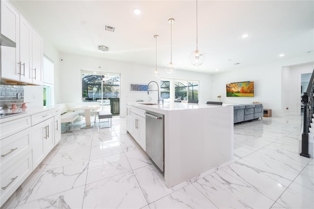 kitchen featuring sink, white cabinetry, decorative light fixtures, a center island with sink, and dishwasher