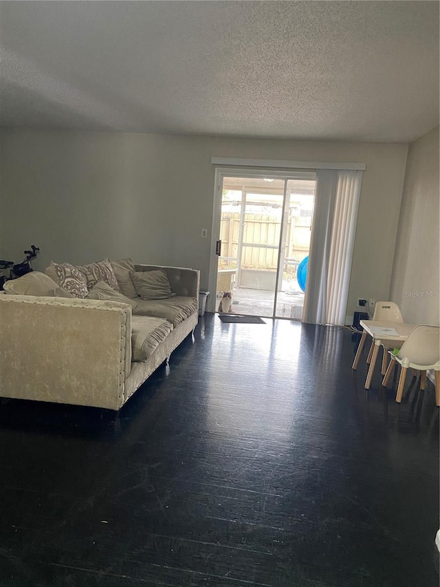 living room with dark hardwood / wood-style floors and a textured ceiling