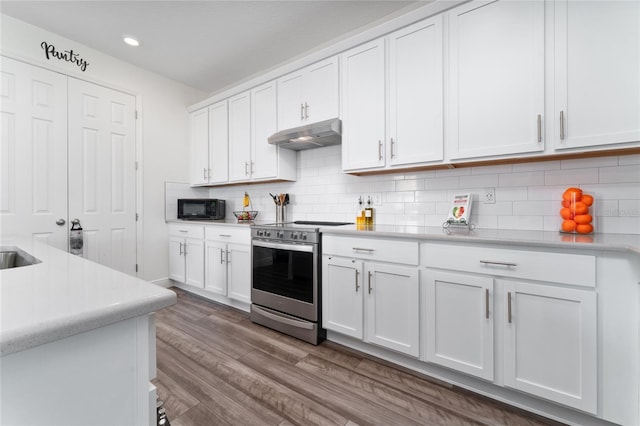 kitchen with hardwood / wood-style floors, electric range, decorative backsplash, and white cabinets