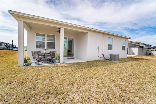 rear view of property featuring ceiling fan, a lawn, a patio, and central air condition unit