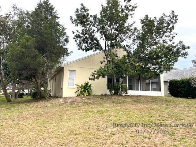 rear view of property with a yard and a sunroom