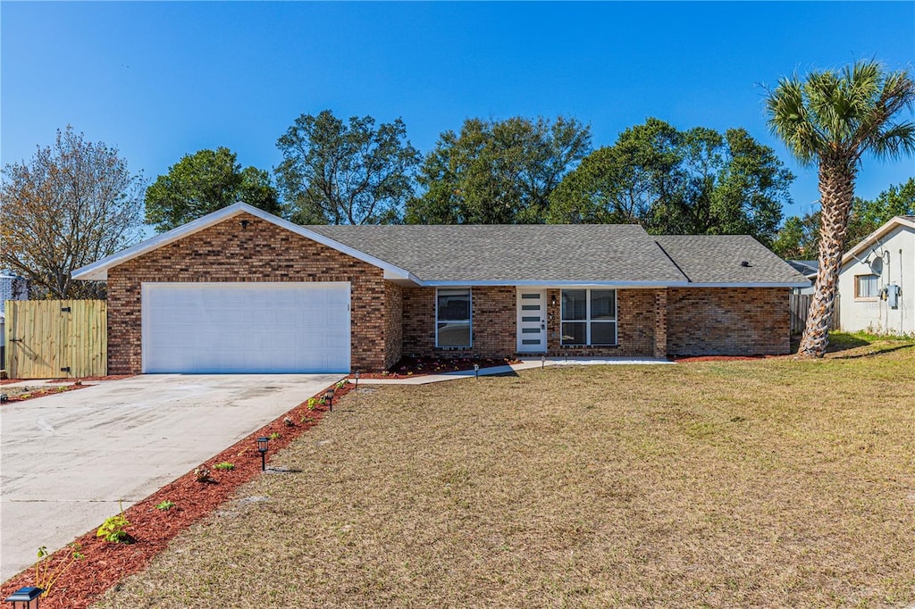 ranch-style home with a garage and a front lawn