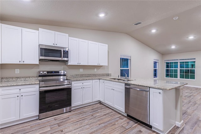 kitchen with white cabinetry, stainless steel appliances, and kitchen peninsula