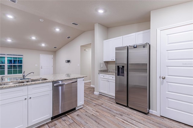 kitchen with white cabinetry, sink, light stone counters, light hardwood / wood-style floors, and stainless steel appliances