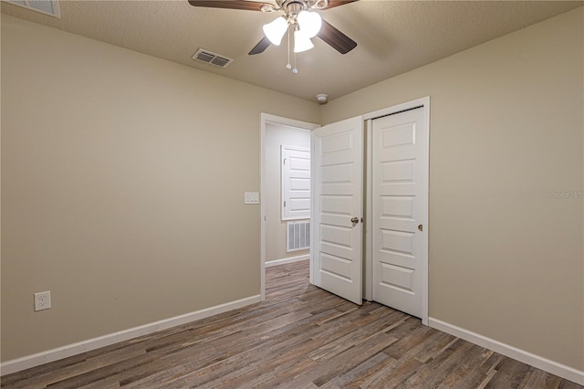 unfurnished bedroom featuring hardwood / wood-style flooring, ceiling fan, a closet, and a textured ceiling