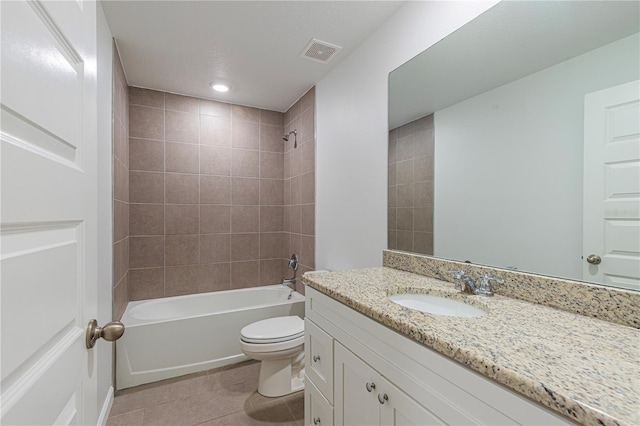 full bathroom with tiled shower / bath combo, vanity, tile patterned flooring, and toilet