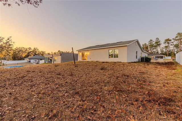 back house at dusk with central AC unit