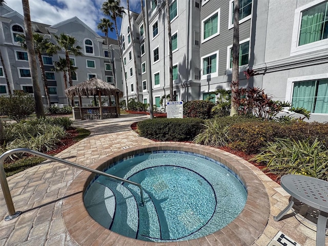 view of swimming pool with a hot tub and a gazebo