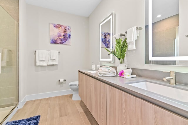 bathroom with vanity, hardwood / wood-style flooring, a shower with door, and toilet