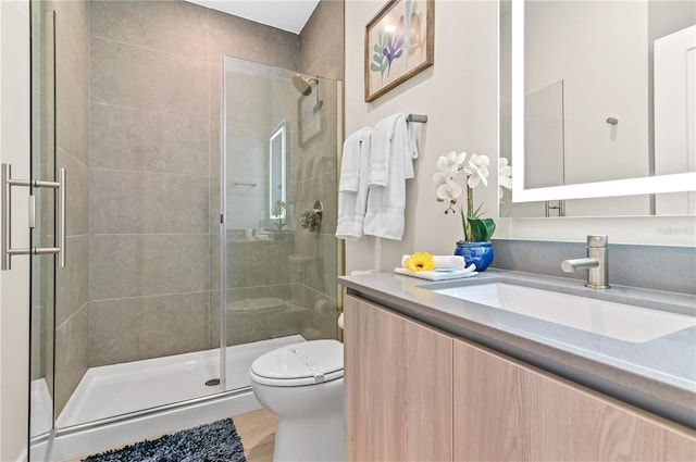 bathroom featuring vanity, an enclosed shower, and toilet