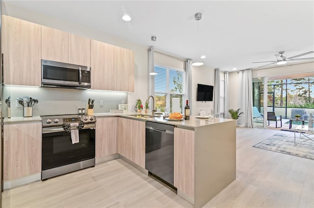 kitchen with a healthy amount of sunlight, appliances with stainless steel finishes, sink, and light brown cabinetry