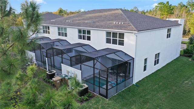 rear view of house with a patio area, a lawn, and glass enclosure