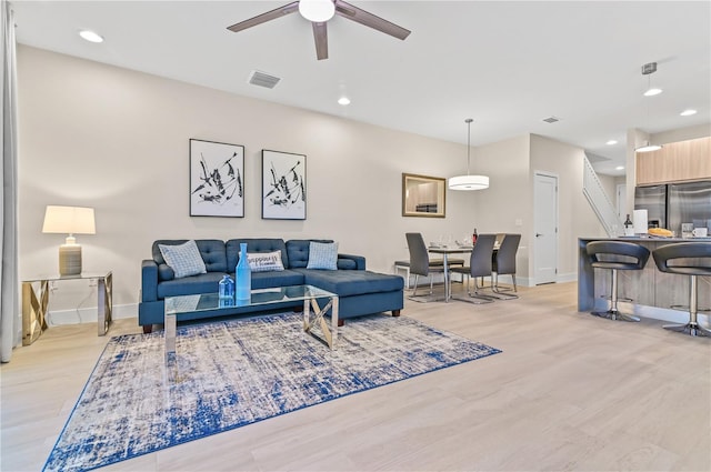 living room featuring ceiling fan and light hardwood / wood-style flooring