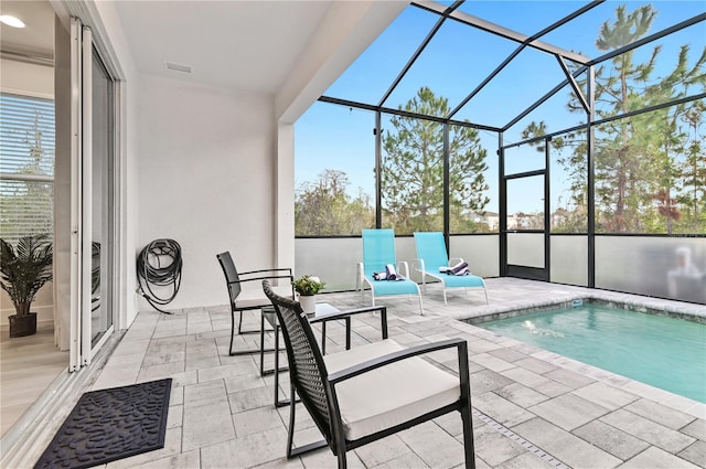 view of swimming pool featuring glass enclosure and a patio area