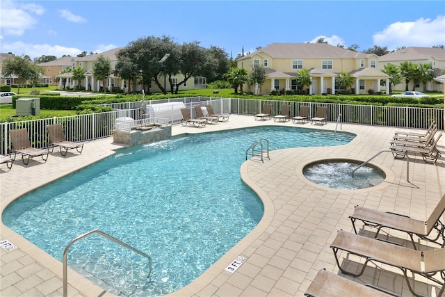 view of pool with a community hot tub, pool water feature, and a patio area