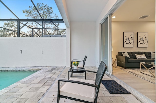 view of patio featuring an outdoor hangout area and glass enclosure