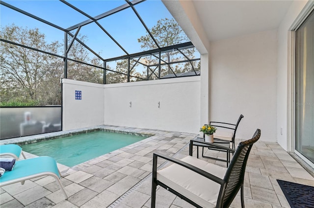 view of swimming pool with a patio and a lanai